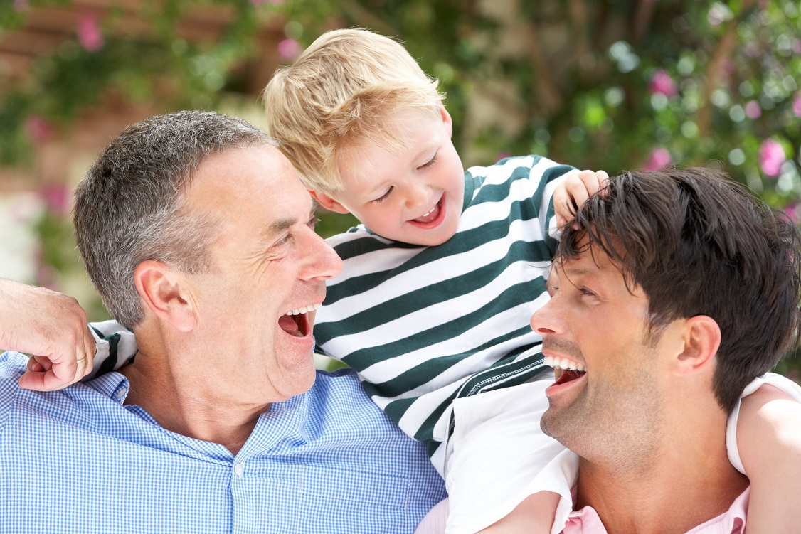 Father and grandfather laughing with grandchild Family Photo